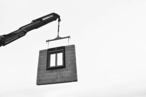 Fenster in einer Ziegelfertigwand wird mit Kran gehoben.